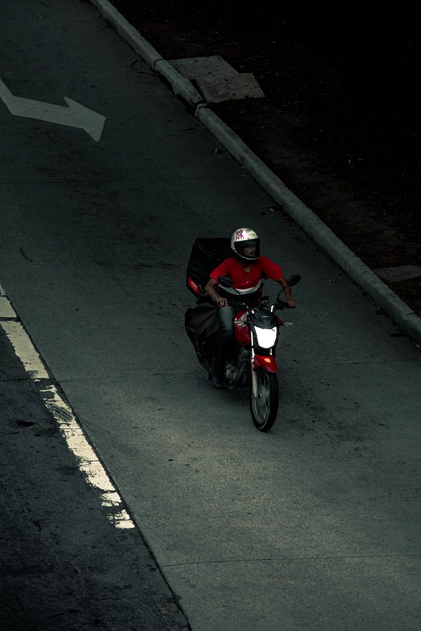 Motociclista em rua de paralelepípedo vista de cima