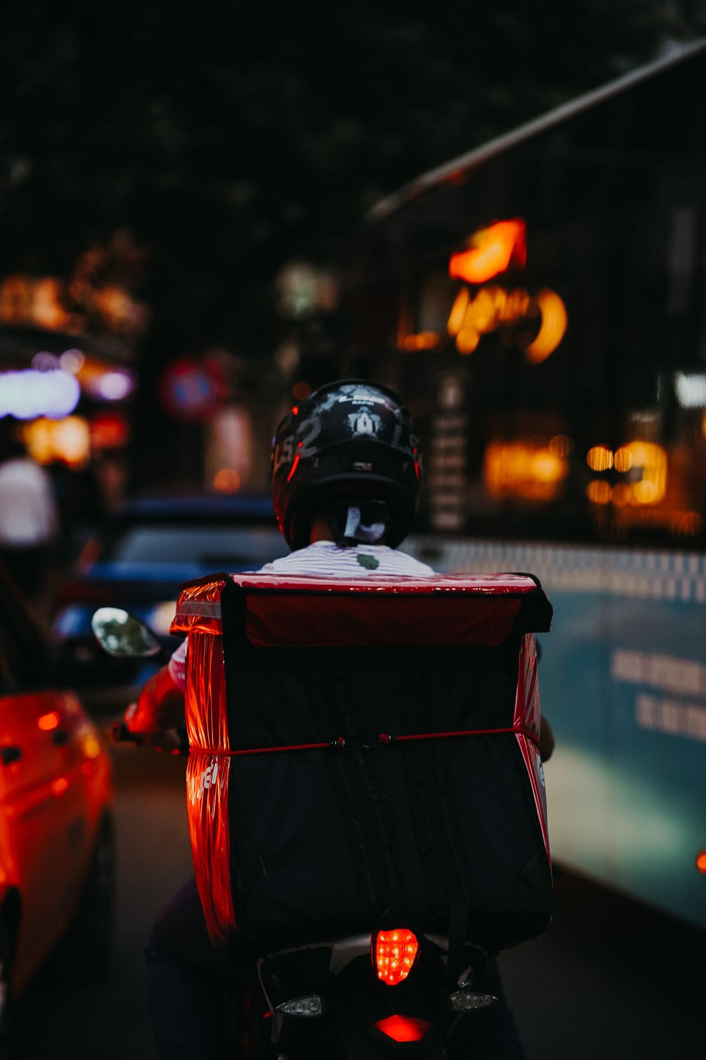 Silhueta de motociclista com lanterna vermelha acesa à noite